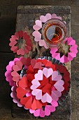 Paper coasters and collars for drinking glasses in shades of red and pink
