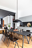 Black, modern dining set in open-plan kitchen of designer loft apartment