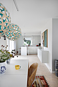 View from dining room into open-plan kitchen entirely in white