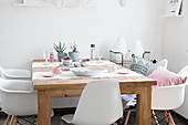 Gedeckter Tisch im Boho-Stil mit weißen Schalenstühlen