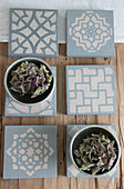Hand-made, concrete-effect tiles with stencilled patterns