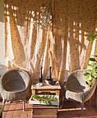 Two weathered wicker chairs in sunny seating area