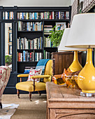 Zwei gelbe Tischleuchten und gelber Sessel im klassischen Wohnzimmer