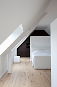 Minimalist attic bedroom with fitted wardrobes under gable ceiling