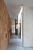 Rough wooden fitted cupboards in corridor with concrete floor