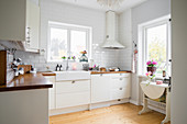 Tiled wall and window in white fitted kitchen