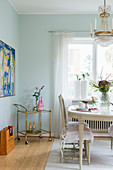 Antique Swedish dining table, chairs and serving trolley in dining room with mint-green walls
