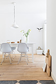 Essbereich im Weiß: Esstich und Klassikerstühle auf Holzdielenboden