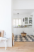 Blick in weiße Küche mit schwarz-weißen Marmor-Bodenflliesen