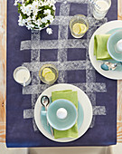 Place settings with boiled eggs on purple tablecloth