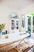 Dining table, chairs and bench in front of vintage bookcase next to terrace doors