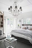Chandelier in the elegant bedroom in gray and white