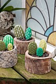 Decorative arrangement of pebbles painted to resemble cacti in pots