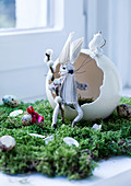 Hand-made cloth rabbit sitting in egg shell