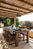 Set dining table and chairs on roofed terrace
