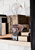 Ax in a leather sheath and lamp in the wooden block on the bookshelf