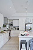 Große moderne Küche ganz in Weiß mit Kücheninsel