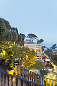 Elegant Mediterranean villa with hillside garden, at dusk
