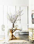 Round wooden designer table and white designer metal chairs on animal fur rug