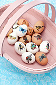 Easter eggs decorated with stickers in trug basket