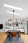 Dining area featuring skylights, low sideboard and gallery of pictures