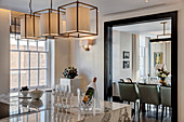 Champagne on kitchen island with marble worksurface and view into dining room