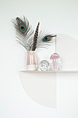Feathers in jug on artistic metal shelf
