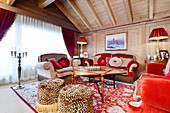 Opulent velvet sofas in red and grey in extravagant living room