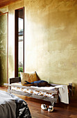 Cot in front of a wall with patinated brass cladding