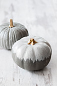 Pumpkins painted grey with white stripes and grey ombré