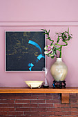 Ornamental cabbage and lucky bamboo in vase against pink wall
