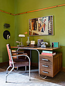 Old wooden desk with metal frame against green wall