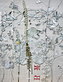 Pressed and painted flowers, leaves and twigs on old fabric
