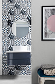 Geometric tiles in bathroom, washstand with countertop sink and round mirror