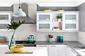 White kitchen counter against pale grey wall with white subway tiles