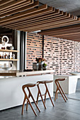 Abstract bar stools at counter in artistic, architect-designed house