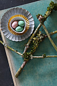 Easter eggs in sweet cases and branches covered with moss and lichen