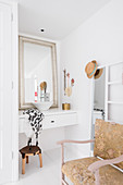 Antikstuhl und Spiegel mit Leiter vor kleinem Waschtisch in weißem Badezimmer