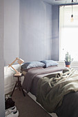 Double bed in bedroom with grey wall