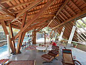 Wohnzimmer mit Designermöbeln im modernen Haus aus Glas und Holz