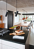 Brot auf der Kücheninsel, Blick über den Esstisch mit Holzplatte