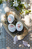 Artistically painted Easter eggs on cress in wooden dish