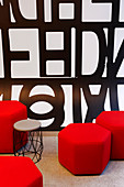 Red hexagonal pouffes and side table in lobby