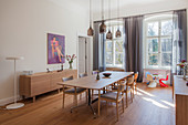Simple timeless wooden furniture in dining room with period windows