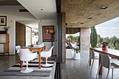 Classic chairs in dining area next to open terrace doors and table and chairs on roofed terrace