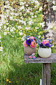 Spring flowers in spherical vases in garden