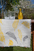 Table runner printed with yellow and grey feathers