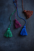 Hand-made tassels in various colours on black surface