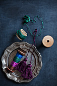 Reels of thread, hand-made tassels and thread wrapped around cardboard tube