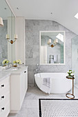 Bright bathroom with marble tiles and free-standing bathtub